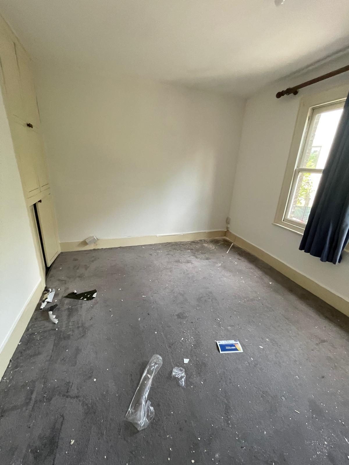A room at the end of a project: bare floor, plaster dust, offcuts and packaging still in place.